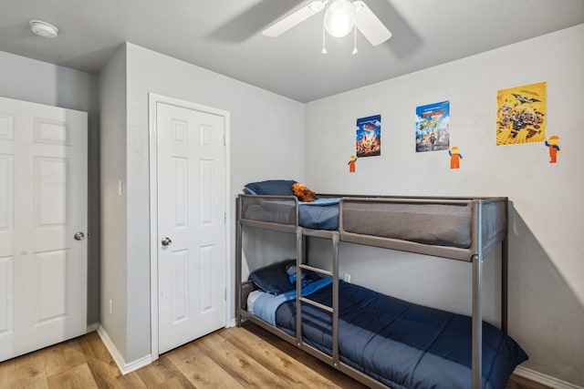 bedroom with baseboards, a ceiling fan, and wood finished floors