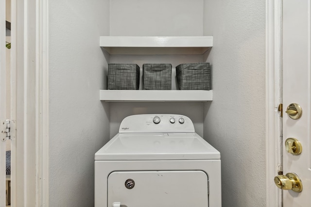 laundry room featuring a textured wall, washer / clothes dryer, and laundry area