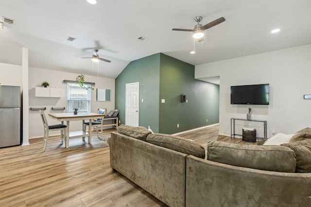 living area with a ceiling fan, lofted ceiling, visible vents, and light wood-style flooring