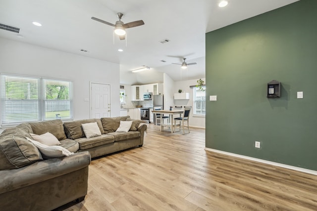 living area with light wood-style floors, visible vents, and plenty of natural light