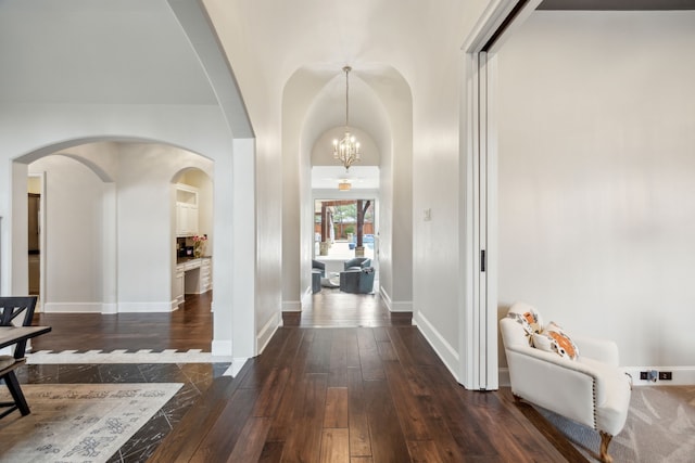 entrance foyer featuring a notable chandelier, dark wood-type flooring, and baseboards