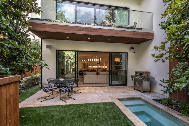 back of house featuring a patio area, fence, an in ground hot tub, and stucco siding