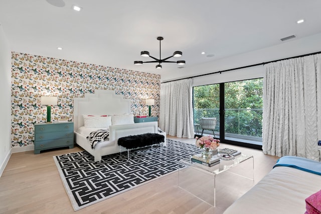 bedroom with a notable chandelier, wood finished floors, visible vents, baseboards, and access to exterior