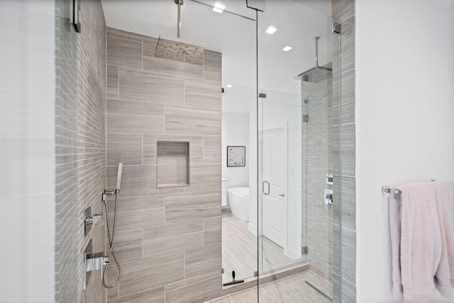 bathroom with a soaking tub and a shower stall