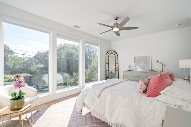 bedroom with a ceiling fan, visible vents, and wood finished floors