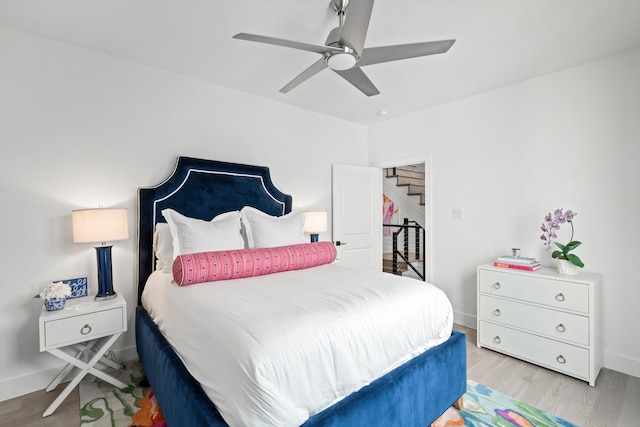 bedroom with wood finished floors, a ceiling fan, and baseboards