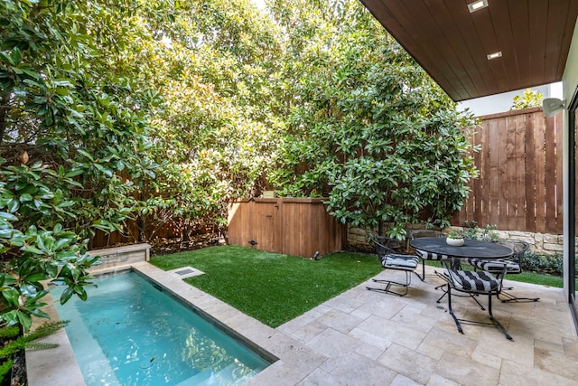 view of swimming pool featuring a fenced in pool, a patio, a fenced backyard, outdoor dining area, and a yard