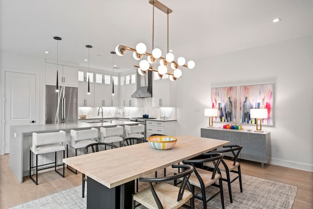 dining area with recessed lighting, light wood-type flooring, and baseboards