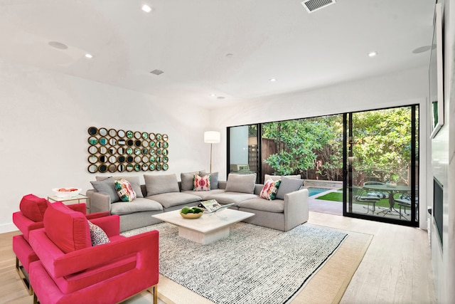 living area with wood finished floors, visible vents, and recessed lighting