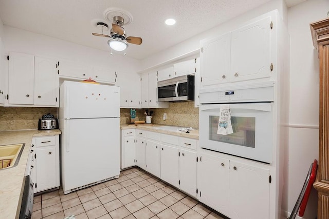 kitchen with white cabinetry, white appliances, backsplash, and light countertops