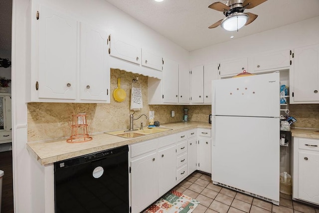 kitchen with tasteful backsplash, black dishwasher, freestanding refrigerator, white cabinetry, and a sink