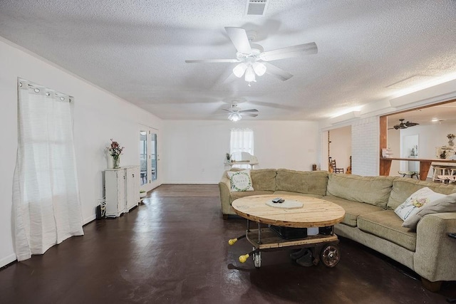 living area with ceiling fan, visible vents, and a textured ceiling