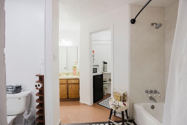 bathroom featuring a textured ceiling, shower / bath combo, vanity, and toilet