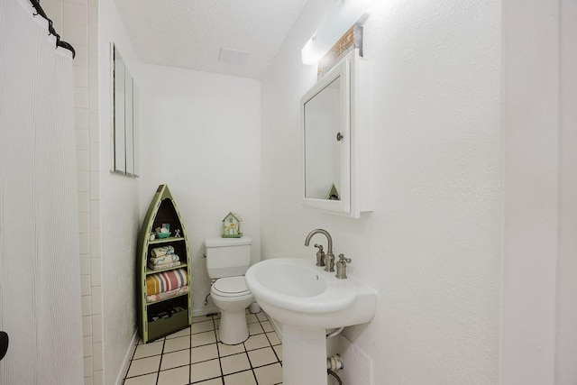 full bath featuring walk in shower, tile patterned floors, toilet, and a textured ceiling