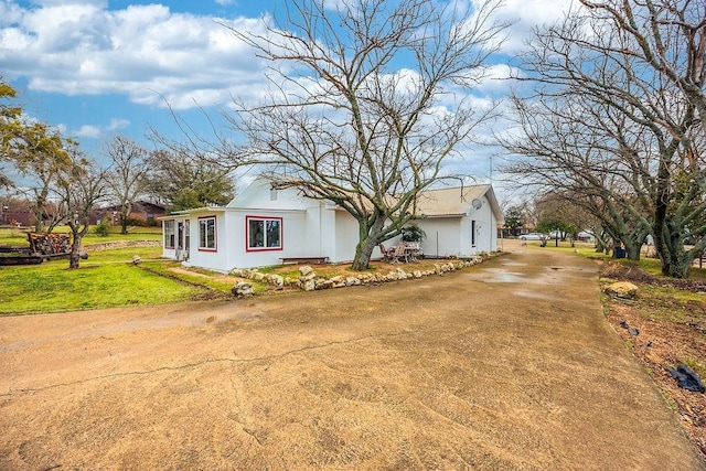 view of front facade with concrete driveway and a front yard