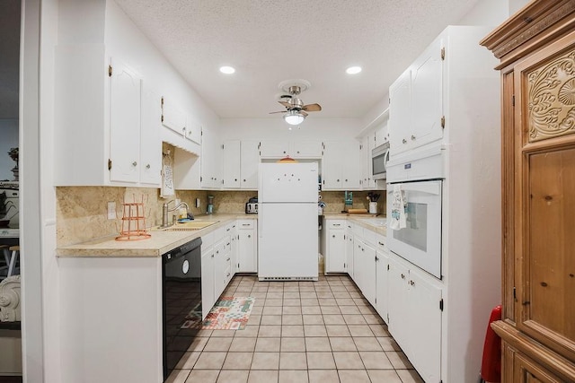 kitchen featuring a ceiling fan, a sink, white cabinetry, white appliances, and light countertops