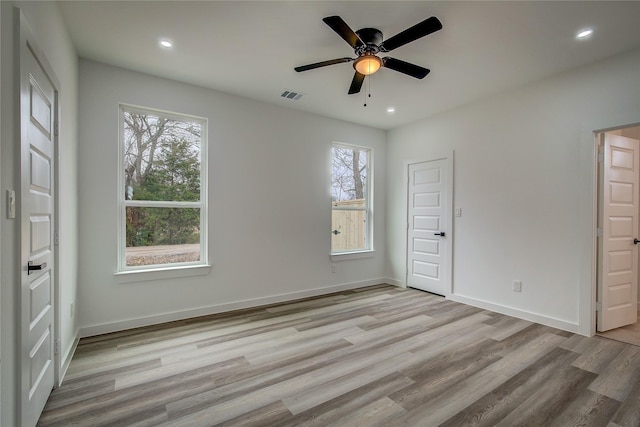 spare room with recessed lighting, visible vents, baseboards, and wood finished floors