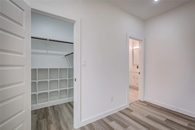 unfurnished bedroom featuring a closet, wood finished floors, and baseboards