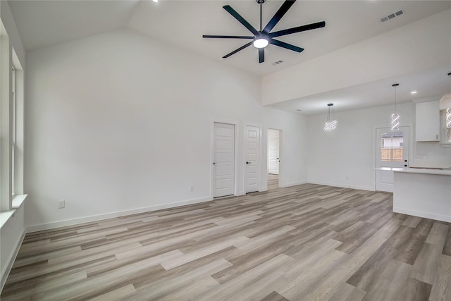 unfurnished living room featuring light wood-style floors, vaulted ceiling, ceiling fan, and baseboards