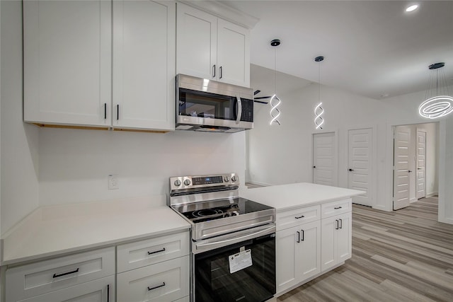 kitchen with decorative light fixtures, light countertops, appliances with stainless steel finishes, white cabinetry, and light wood-type flooring