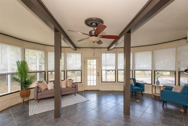 sunroom featuring beam ceiling, a wealth of natural light, and ceiling fan