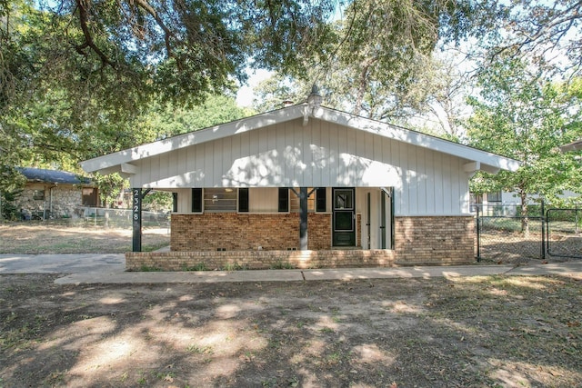 view of front of property with a gate, fence, and brick siding