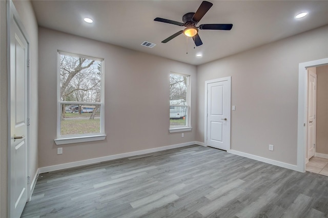 unfurnished bedroom with baseboards, visible vents, connected bathroom, wood finished floors, and recessed lighting