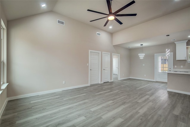 unfurnished living room with light wood-type flooring, baseboards, visible vents, and ceiling fan