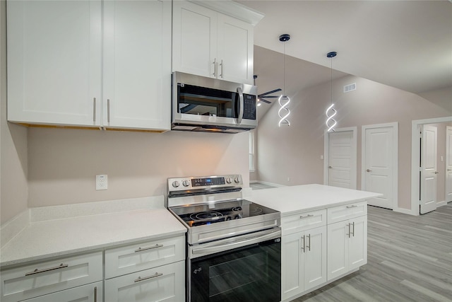 kitchen featuring stainless steel appliances, light wood-style floors, white cabinets, hanging light fixtures, and light countertops