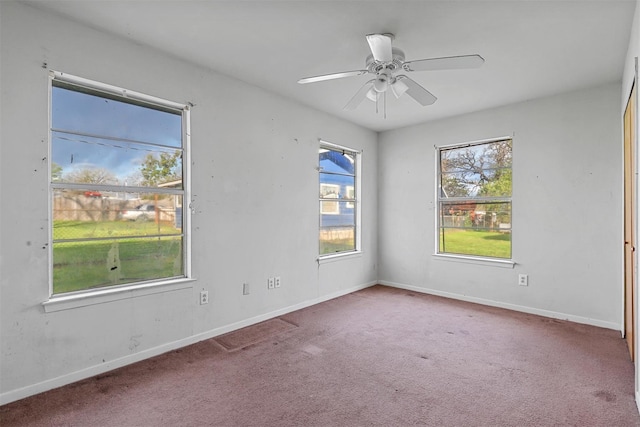 carpeted empty room featuring ceiling fan and baseboards