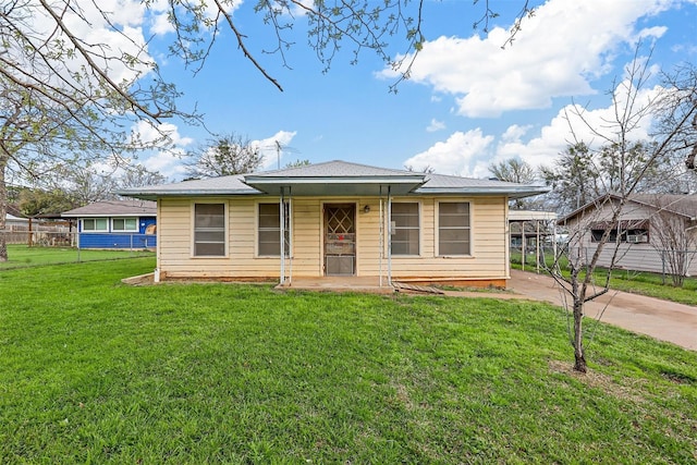 bungalow featuring concrete driveway, a front lawn, and fence