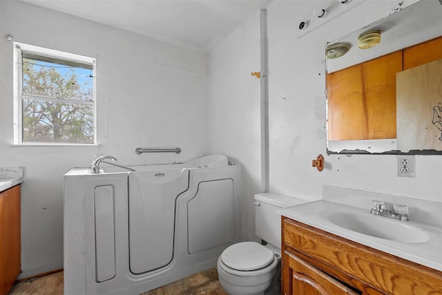 full bathroom featuring a garden tub, vanity, and toilet