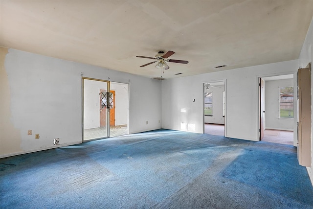 carpeted spare room featuring ceiling fan and visible vents