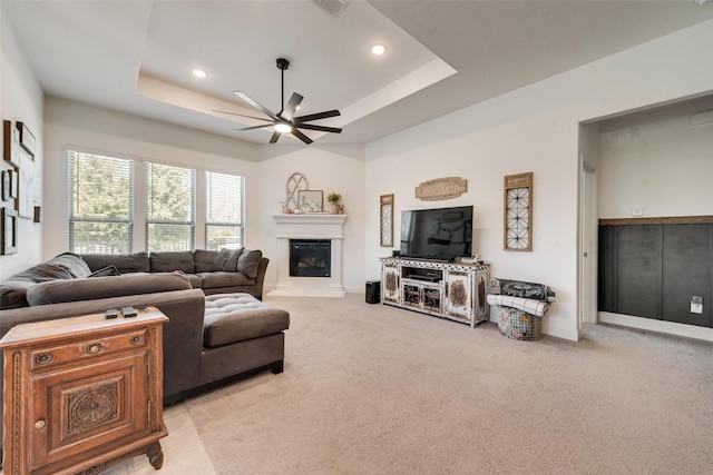215 Tallgrass Dr, Lavon, TX 75166 - living area with a ceiling fan, a raised ceiling, light carpet, a glass covered fireplace, and recessed lighting