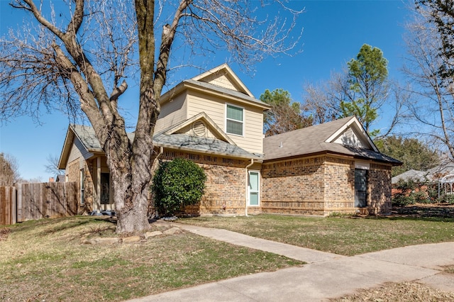 view of front of property featuring brick siding, a front yard, and fence