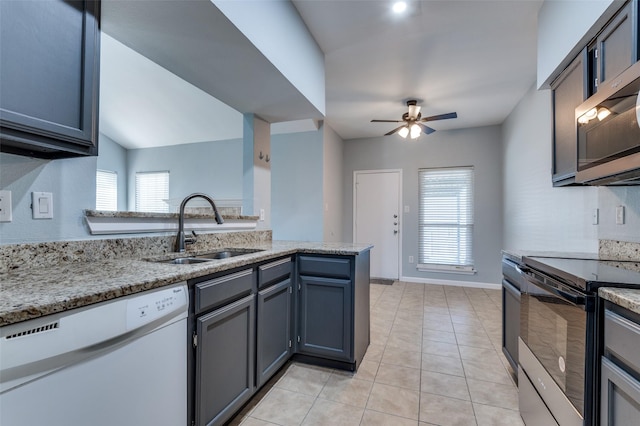 kitchen featuring a wealth of natural light, black electric range oven, stainless steel microwave, a sink, and dishwasher