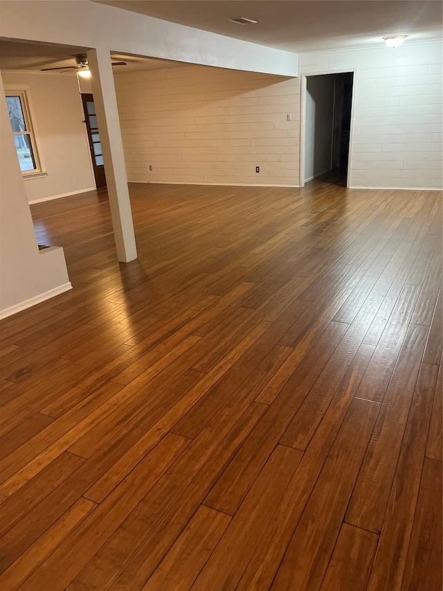 below grade area featuring ceiling fan and dark wood-style flooring