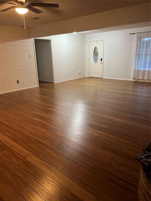 unfurnished living room featuring visible vents, ceiling fan, a textured ceiling, and wood finished floors