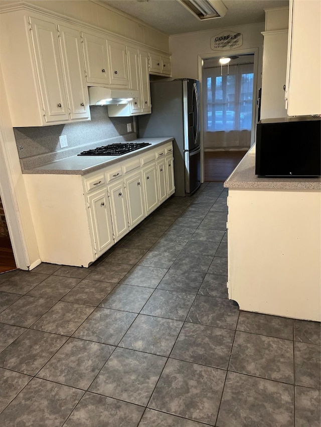 kitchen with under cabinet range hood, gas cooktop, white cabinets, and stainless steel fridge with ice dispenser