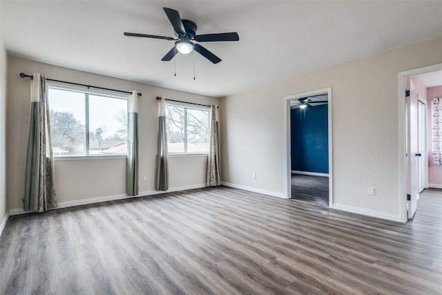 spare room featuring baseboards and wood finished floors