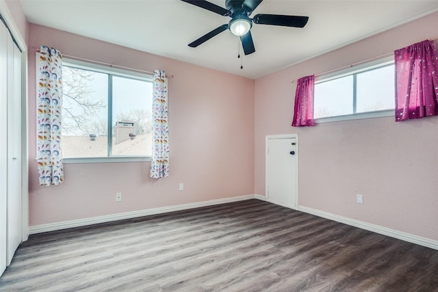 spare room featuring a ceiling fan, baseboards, and wood finished floors