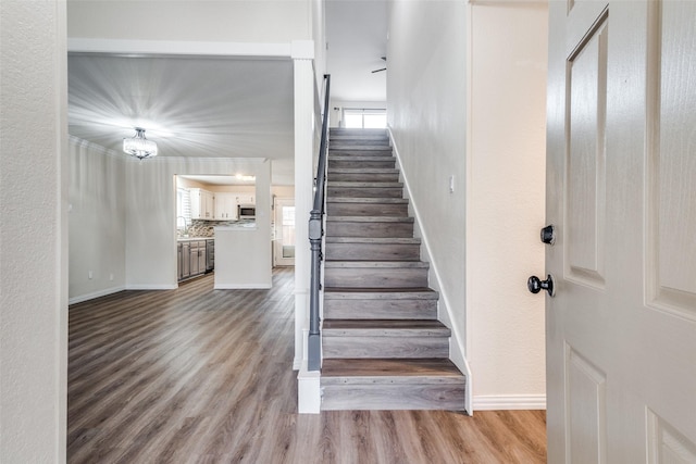 stairway with wood finished floors and baseboards