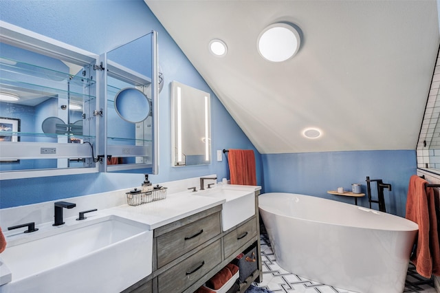 bathroom with vaulted ceiling, double vanity, a freestanding tub, and a sink