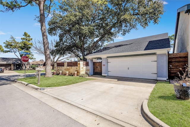 view of front of property with stucco siding, a shingled roof, fence, a garage, and driveway