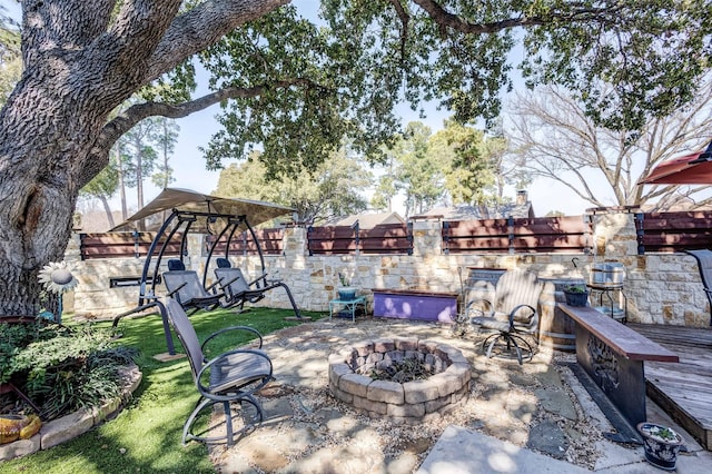 view of patio / terrace featuring an outdoor fire pit and fence