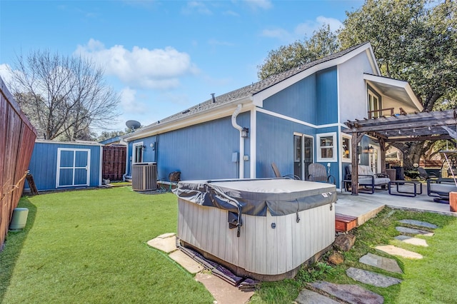 back of house featuring a storage shed, a hot tub, an outdoor structure, a patio area, and a pergola