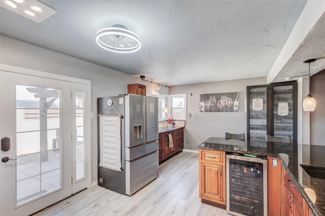 kitchen with wine cooler, light wood-type flooring, stainless steel fridge, and brown cabinets