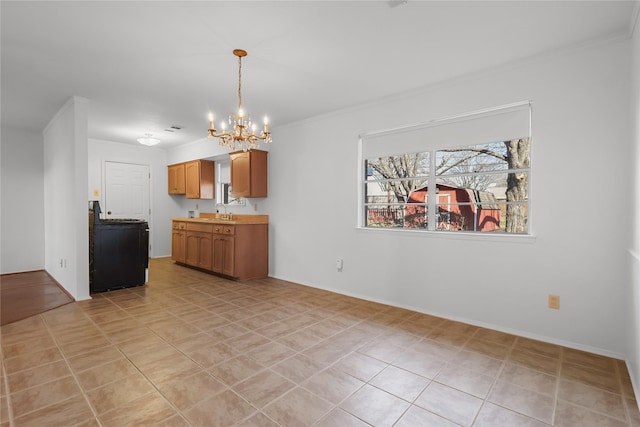 kitchen with a chandelier, light tile patterned flooring, a sink, light countertops, and pendant lighting