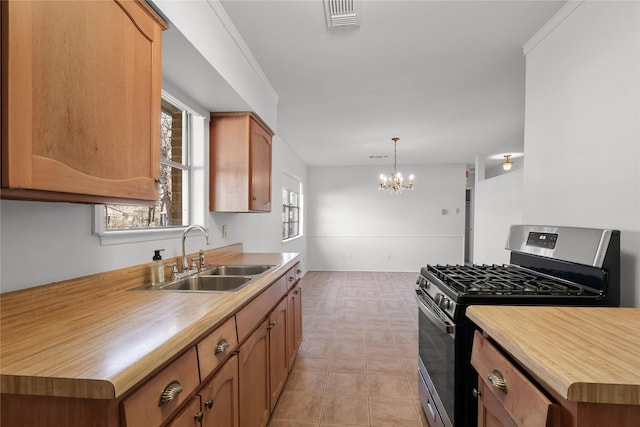 kitchen with a sink, visible vents, an inviting chandelier, gas stove, and pendant lighting