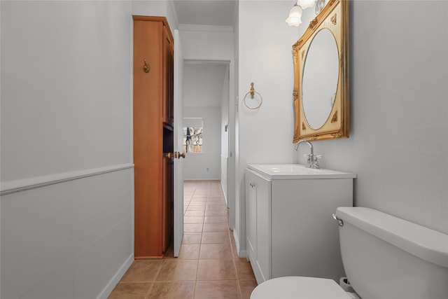 half bath featuring toilet, tile patterned flooring, and vanity